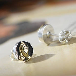 Vintage stainless steel round stud earrings featuring gold-colored praying hands relief