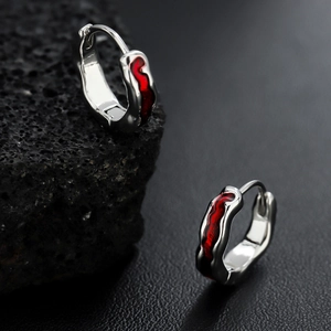 Silver hoop earrings with red wave enamel pattern shown on black stone and leather