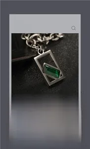 Gros plan d'un collier chaîne argenté avec un pendentif rectangulaire en pierre verte