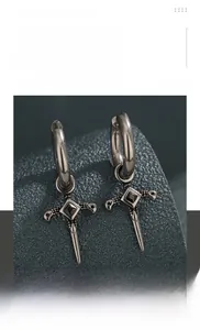 Detailed macro view of titanium steel cross hoop earring with black zircon stone