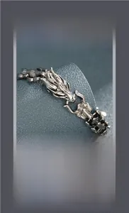 Detailed close-up of a vintage silver dragon head bracelet with relief craftsmanship