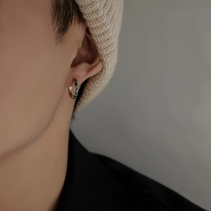 Neutral S925 sterling silver hoop earring with black star pattern worn by a model