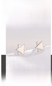 Détail des boucles d'oreilles étoiles en acier titane argenté poli pour un style chic