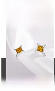 Gros plan sur des boucles d'oreilles étoiles en acier titane avec texture dorée