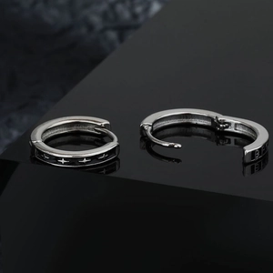 Unisex silver star stud earrings with black enamel inlay and engraved punk details