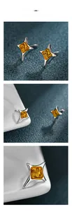 Détails macro de boucles d'oreilles étoile à quatre branches en argent et jaune