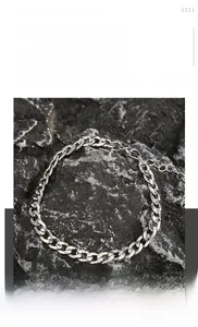 Dettaglio della collana a catena cubana in acciaio al titanio argento su pietra scura
