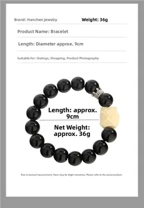 Detail view of black obsidian bracelet with white lion head bead and silver crown charm