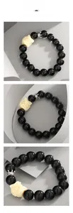 Detailed view of obsidian bead bracelet with carved lion head charm and silver crown bead