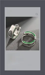 Close-up of s925 silver huggie hoop earrings with green enamel and dotted texture