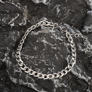 Bracciale a catena cubana in acciaio inossidabile argento lucido per uomo e donna su fondo roccia