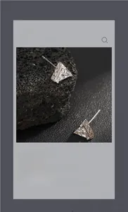 Macro shot of silver triangle stud earring with clear zircon and vintage engraving