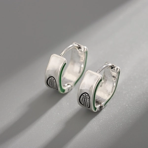 Minimalist silver avocado earrings with green enamel and black textured detailing