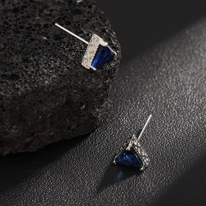 Triangle blue sapphire zircon stud earrings with engraved silver metal on dark rock