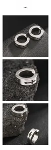 Gros plan sur l'ear cuff en titane avec motifs croix noires sur fond de roche noire texturée