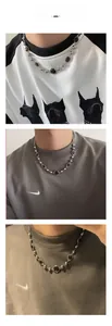 Détail macro d'un collier rétro en pierre œil de tigre avec chaîne perlée argentée