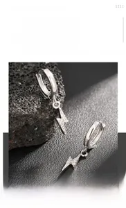 Gros plan de boucles d'oreilles éclair argentées avec des zircons blancs brillants