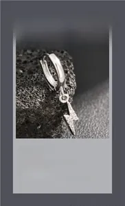 Détail macro de boucles d'oreilles éclair serties de zircons étincelants