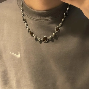 Collier en pierre œil de tigre avec perles argentées porté avec un sweat gris