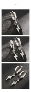 Détails de boucles d'oreilles éclair argentées avec zircons sur cuir noir texturé