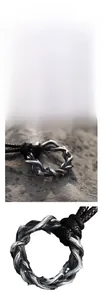 Gros plan du pendentif épines avec finition vintage et cordon en cuir tressé noir