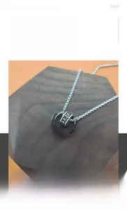 Macro detail of rotating titanium steel pendant with engraved Six-Syllable Mantra characters