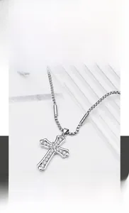 Vue macro du pendentif croix en acier titane argenté avec zircone sur chaîne box