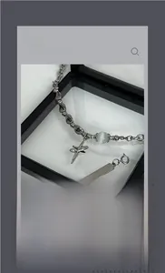 Macro shot of silver star and rectangle pendant necklace with blue bead detail in gift box