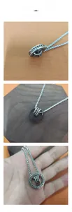 Macro detail of rotating silver pendant with engraved Buddhist mantra on vintage chain