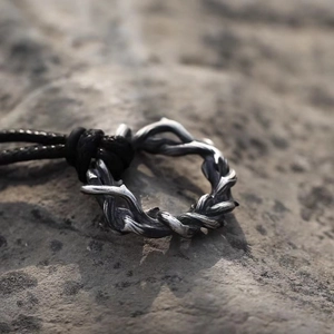 Pendentif épines rétro punk en métal argenté avec cordon en cuir noir sur pierre