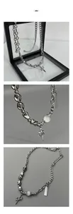 Macro detail of silver sword cross pendant with metallic beads and white orb on display