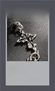 Vue macro du pendentif croix gothique avec émail noir et chaîne en métal épais