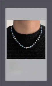 Détail de perles bleues texturées et de perles argentées sur un collier hip-hop chic
