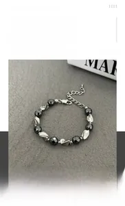 Detailed shot of metallic beads and grey stones bracelet with lobster clasp and chain