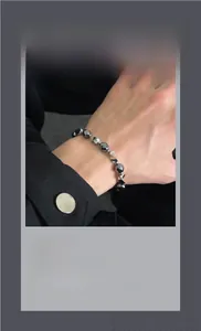 Detailed view of faceted hematite beads and twisted metal links on the wristband