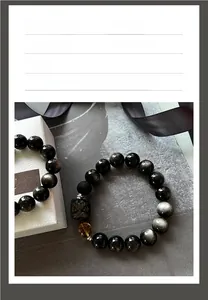 Vue détaillée du bracelet en perles d'obsidienne avec éclat doré et breloque pixiu