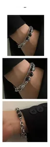 Close-up of double-layer titanium steel bracelet with cracked beads on a suit sleeve
