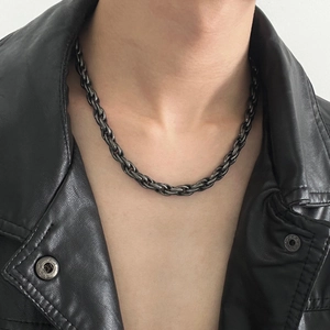 Collier chaîne torsadée noire pour homme porté sur une veste en cuir noir élégante
