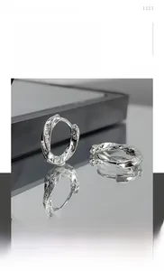 Détail de boucles d'oreilles Mobius en acier titane argenté avec incrustation strass