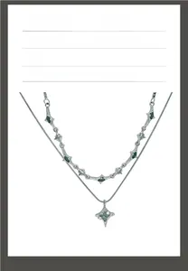Detail of double-layer titanium steel necklace with green zircon and star pendant