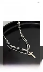 Détail du collier croix multicouche en acier titane avec chaîne à billes et pendentif