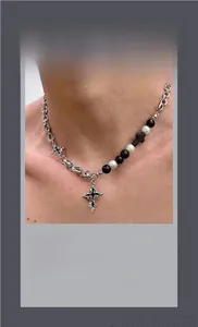 Detailed close-up of gothic cross necklace featuring black beads and white pearls