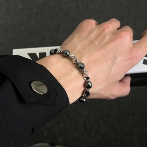 Sleek hematite beaded bracelet with silver metallic accents on a male model's wrist