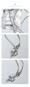 Détail macro du collier serpent argenté avec pendentif étoile et lune sur glaçons