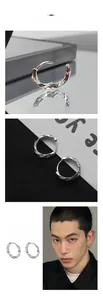 Détail macro des boucles d'oreilles Mobius argentées avec gravure et texture torsadée