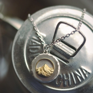 Collier avec pendentif relief montagne en acier titane bicolore et texture martelée