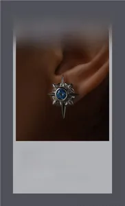 Detailed close-up of a vintage silver star stud earring featuring a blue sapphire gem