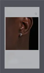 Gros plan de boucles d'oreilles créoles croix en argent serties de diamants sur modèle