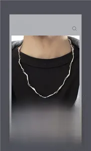 Detailed view of wave-shaped titanium steel links on a minimalist silver unisex necklace