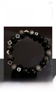 Gros plan de perles d'obsidienne avec croix en argent et breloque boule de billard n°8